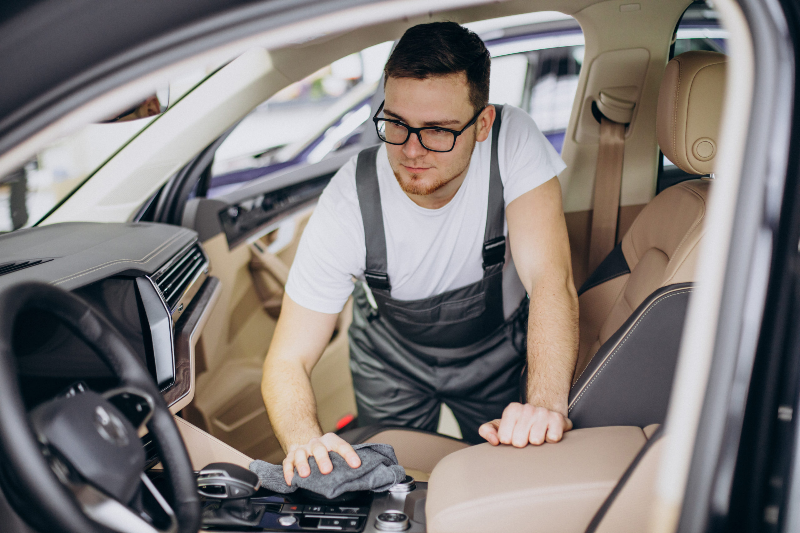 Mechanic polishing the interior of a car during a service session.